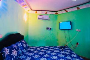 a bedroom with a bed and a tv on the wall at point de distraction in Foumban +9 photos