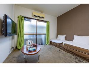 a room with a bed and a tv and a table at Sora / Vacation STAY 1124 in Sakai