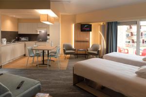 a hotel room with two beds and a kitchen at Floreal Blankenberge in Blankenberge
