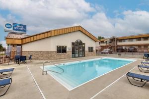 a pool at a hotel with chairs and a building at Best Western Plains Motel in Wall