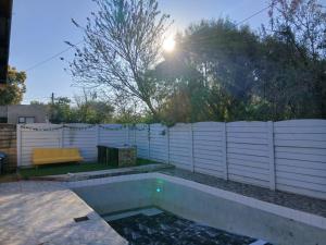 a swimming pool in a backyard with a white fence at Cooperville 1 in Potchefstroom