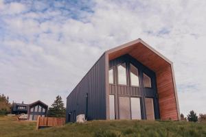 a house with large windows on top of a hill at Modern Nordic Cabin 1 w/ Hot Tub & Views in East LaHave
