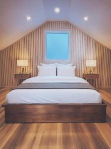 a bedroom with a large bed with two lamps at Modern Nordic Cabin 1 w/ Hot Tub & Views in East LaHave