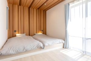 two beds in a room with a window at The Wave - Vacation STAY 62368v in Hokota