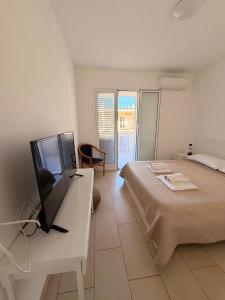 a bedroom with a bed and a desk with a television at Villetta del Moro in Villaggio Azzurro