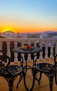 a table and chairs on a balcony with the sunset at Enjoy complete seclusion at Casa Delfin, featuring your own stunning private pool and sunset views in Gran Alacant