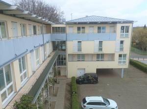 an apartment building with a car parked in a parking lot at Forum Marinar 38 in Bansin