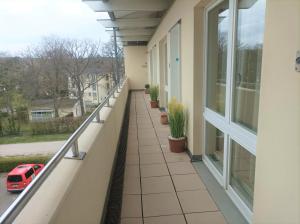 a balcony with plants and a red car on it at Forum Marinar 38 in Bansin
