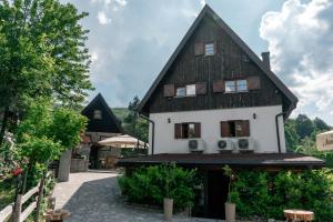 ein großes weißes Haus mit schwarzem Dach in der Unterkunft Rustic Lodge Plitvice in Plitvička Jezera