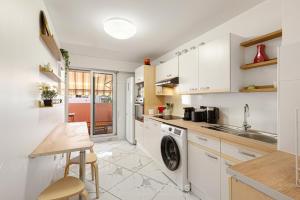 a kitchen with white cabinets and a sink and a dishwasher at Suite Sainte-Hélène FSHH in Nice +12 photos