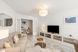 a living room with a couch and a tv at Suite Sainte-Hélène FSHH in Nice