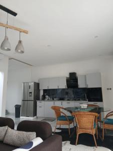 a living room with a table and chairs and a kitchen at Villa Blanche in Cotonou