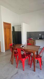 a wooden table and red chairs in a room at Casa roja Depto A in Palenque