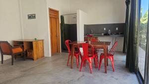 a dining room with a table and red chairs at Casa roja Depto A in Palenque
