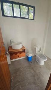 a bathroom with a toilet and a sink and a window at Casa roja Depto A in Palenque