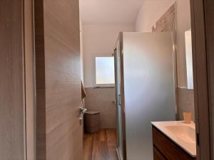 a bathroom with a sink and a toilet and a door at Casa Demelas in Stintino +10 photos