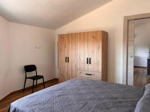 a bedroom with a bed and a cabinet and a chair at Casa Demelas in Stintino
