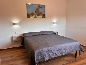 a bedroom with a bed and two lights on the wall at Casa Demelas in Stintino