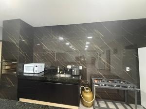 a kitchen with a black counter top with a microwave at Lotus in Gurupi