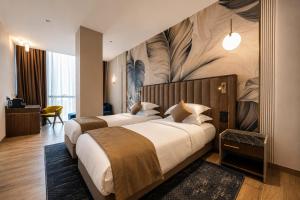 two beds in a hotel room with a mural at Hotel Supreme in El Biar