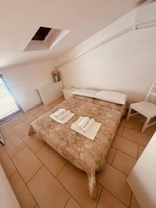 a bedroom with a large bed with two towels on it at Villetta del Moro in Villaggio Azzurro