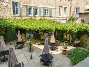 an outdoor patio with umbrellas and chairs and a building at Chateau de Murviel in Murviel
