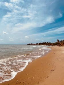 a beach with the ocean and a cloudy sky at Villetta del Moro in Villaggio Azzurro