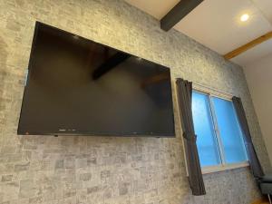 a large flat screen tv hanging on a wall at Koya TRIBE - Vacation STAY 48392v in Oishi +4 photos