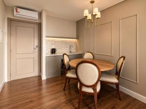 a dining room with a wooden table and chairs at Castelos do Vale by Livá OFICIAL in Bento Gonçalves