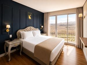 a bedroom with a large bed and a large window at Castelos do Vale by Livá OFICIAL in Bento Gonçalves +34 photos