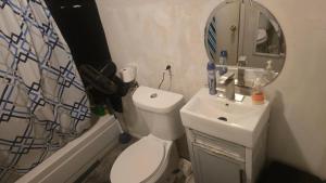 a bathroom with a toilet and a sink and a mirror at Grateful Hemphill in Atlanta +12 photos