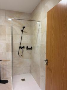a bathroom with a shower with a glass door at Alojamento das cantarinhas in Bragança +14 photos
