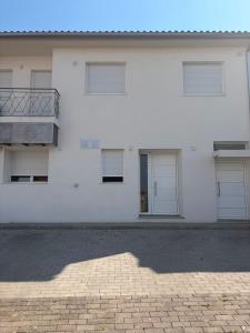 a white building with doors and a balcony at Alojamento das cantarinhas in Bragança