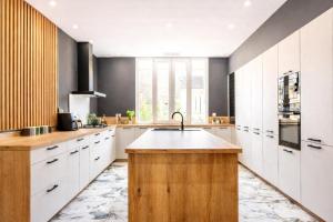 a kitchen with white cabinets and a sink at Villa Prestige - Maison d Hôtes avec Piscine, Billard et Parking Privé - Centre 5 min - Proche A7-A9 in Orange