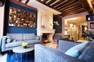 a living room with blue couches and a fireplace at Hôtel Sèvres Saint Germain in Paris