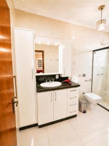 a bathroom with a sink and a toilet at Guest house - Casa do Rogério in Caxias do Sul +45 photos
