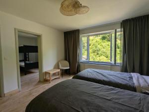 ein Hotelzimmer mit zwei Betten und einem Fenster in der Unterkunft L'Eauberge in La-Roche-en-Ardenne