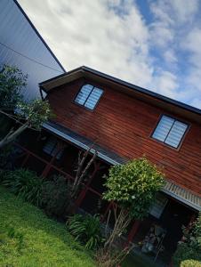 a house with three windows on the side of it at Hostal y Cabañas Guaje in Valdivia