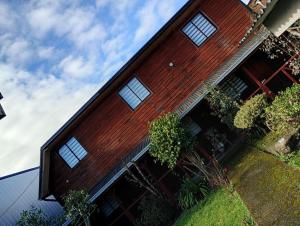 a red house with windows on the side of it at Hostal y Cabañas Guaje in Valdivia
