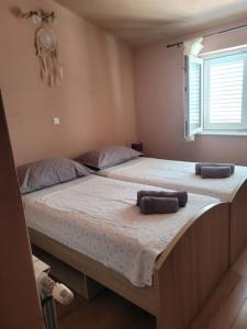 two beds in a room with towels on them at Apartmani Vini in Hvar