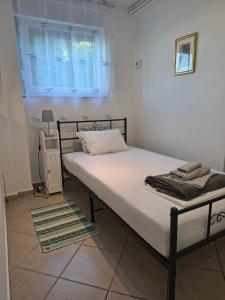 a bed in a white room with a window at Studio apartman Tilia in Veliko Trgovišće