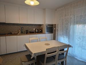 a kitchen with white cabinets and a table and chairs at Studio apartman Tilia in Veliko Trgovišće +11 photos