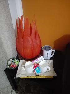 einen Tisch mit Kürbis und zwei Tassen drauf. in der Unterkunft Casa Giorgia in Cefalú