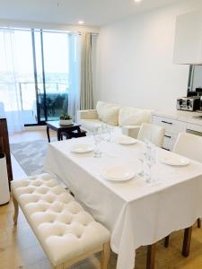 a living room with a white table and chairs at Premium Twin King Ensuites apartment with Double Sofa Bed at M-city Apartment Complex - Infinite Mountain View - Monash Uni & Hospital Clayton, 3168, Victoria, Australia - Free parking, Wifi, Amenities, Tea and Coffee in Clayton North