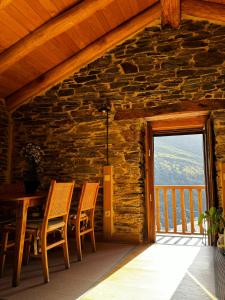 a dining room with a table and chairs and a window at Lar da cima in Folgoso
