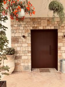 a brown door in a brick wall with plants at Kanaloa Lodge in Galizano