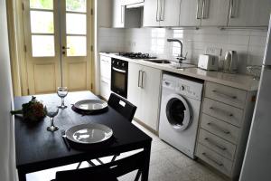 a small kitchen with a table and a washing machine at Chris House in Nicosia