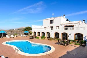 a villa with a swimming pool in front of a building at Clara Suite 3 - Macaronesiahomes in Conil
