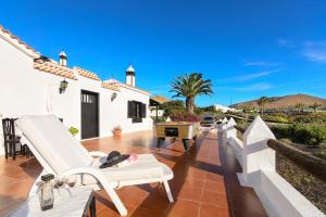 a patio with white chairs and a piano on a house at Clara Suite 3 - Macaronesiahomes in Conil