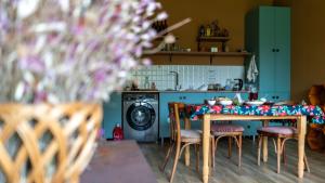 eine Küche mit Tisch und Stühlen sowie einer Waschmaschine in der Unterkunft Bee House in Kilda